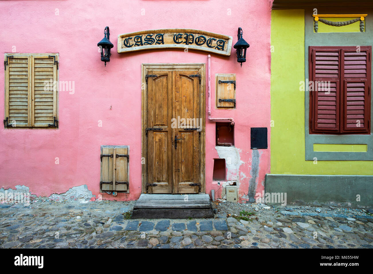 Sighisoara, Romania, August 22, 2016: Wooden door and windows on old rustic pink house in Romanian city in Transylvania Stock Photo