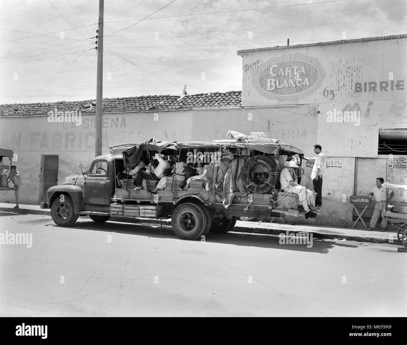 1930s PEOPLE RIDING ON TRUCK BUS WITH OPEN SIDES LUGGAGE PILED IN BACK RURAL MEXICO - asp lt163a ASP001 HARS WRECK Stock Photo