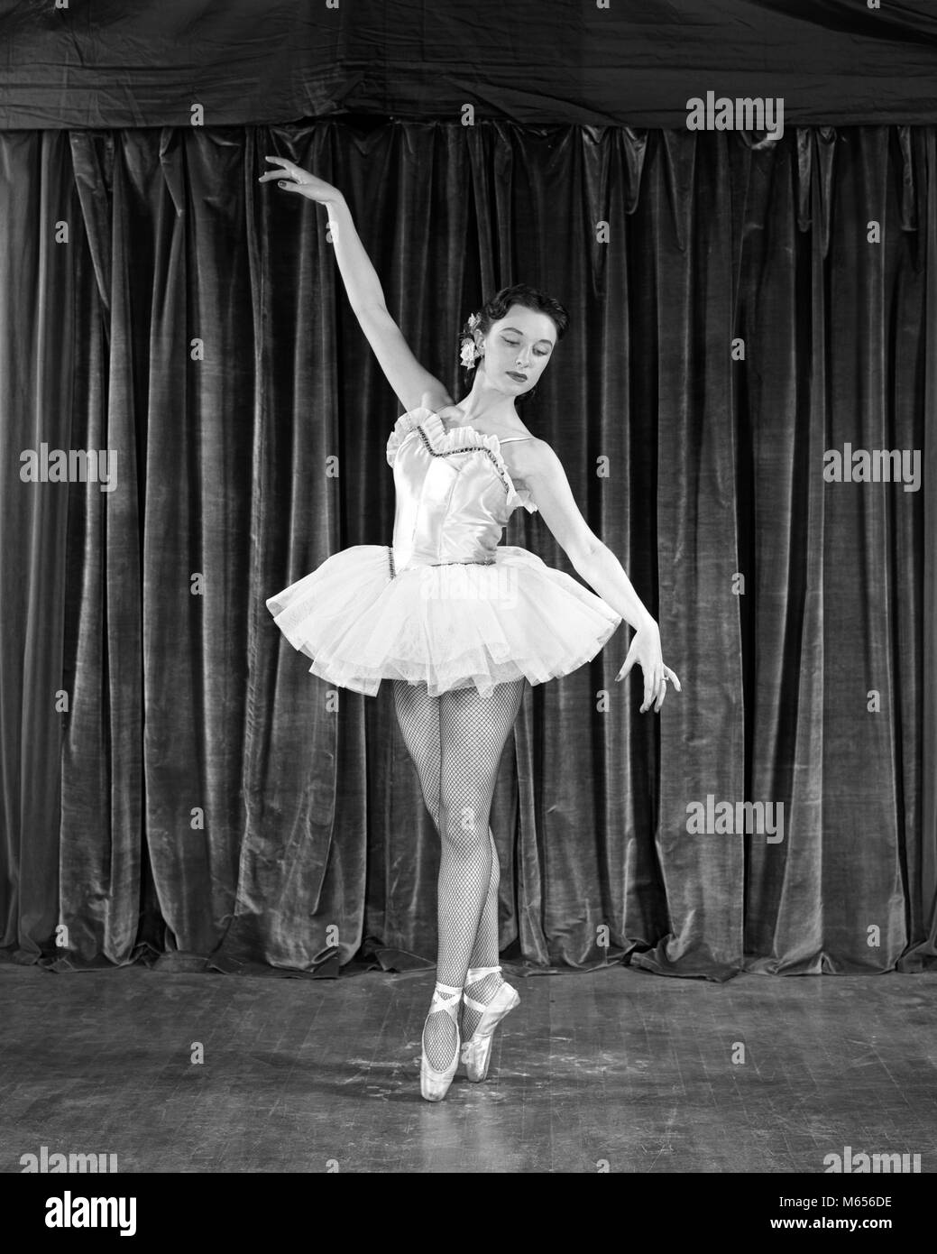 1950s BRUNETTE BALLERINA IN CLASSICAL POSE ON POINTE BEFORE CURTAIN ON  STAGE - d2459 HAR001 HARS BRUNETTE PERFORMING ARTS BEFORE OCCUPATION  PERFORMER CAREERS TUTU 18-19 YEARS BALLERINA ENTERTAINER ACTORS PERFORMERS  SLIPPER ENTERTAINERS