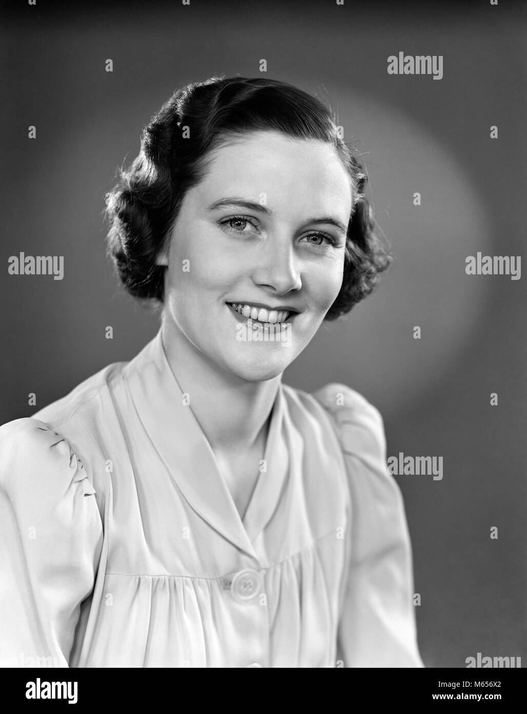 1930s 1940s PORTRAIT OF SMILING WOMAN WEARING BUTTON DOWN BLOUSE LOOKING AT CAMERA - g1974 HAR001 HARS HAPPINESS HEAD AND SHOULDERS CHEERFUL BLOUSE SMILES JOYFUL MID-ADULT MID-ADULT WOMAN PEOPLE ADULTS B&W BLACK AND WHITE CAUCASIAN ETHNICITY LOOKING AT CAMERA OLD FASHIONED PERSONS Stock Photo