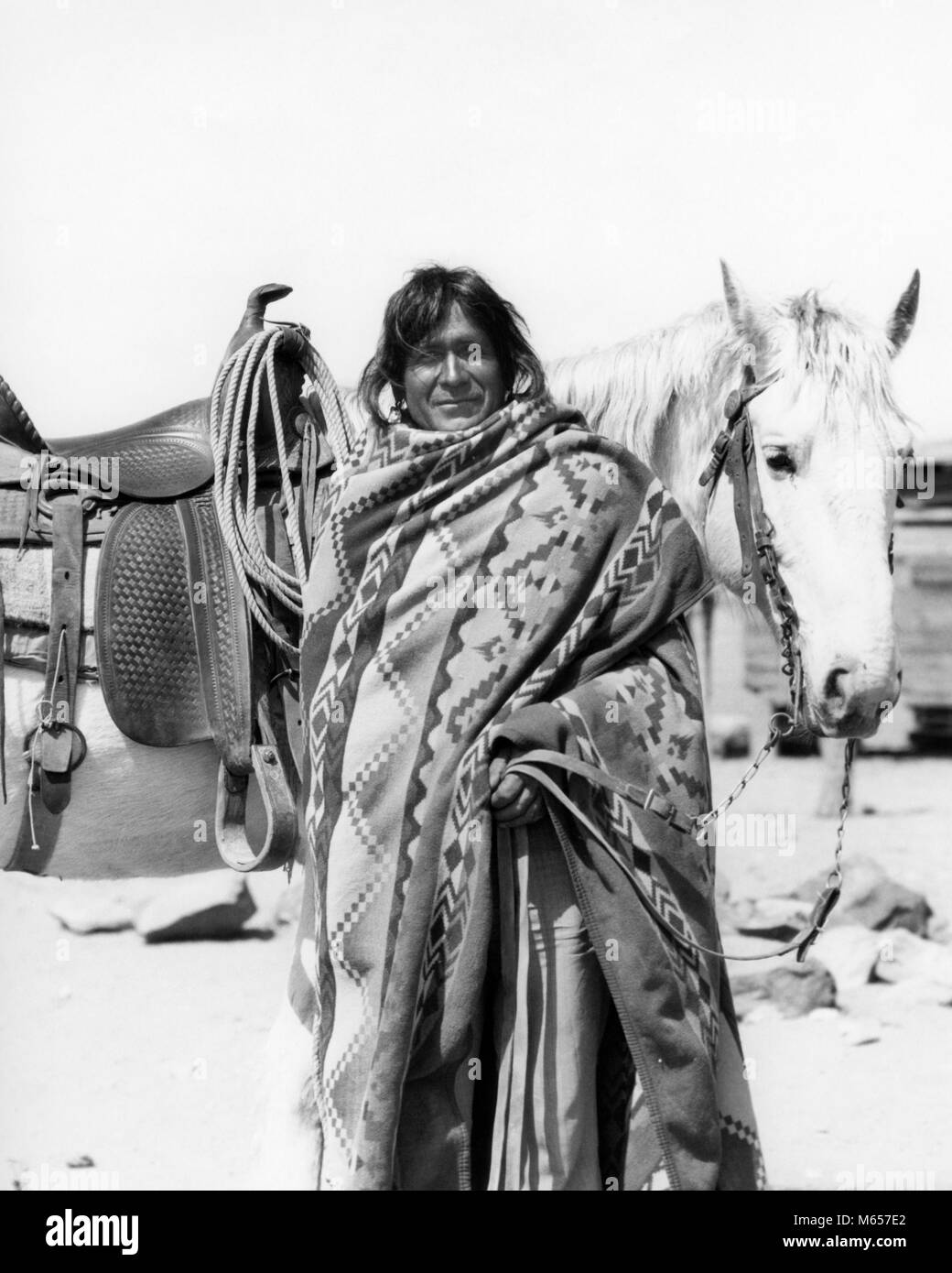 1930s NATIVE AMERICAN INDIAN MAN WEARING BLANKET STANDING BY HORSE LOOKING AT CAMERA COCHITI PUEBLO NEW MEXICO USA - i1279 HAR001 HARS 40-45 YEARS NORTH AMERICAN ONE ANIMAL MAMMALS PRIDE RESERVATION NATIVE AMERICAN PUEBLO COCHITI MALES MAMMAL MID-ADULT MID-ADULT MAN NATIVE AMERICANS NEW MEXICO B&W BLACK AND WHITE INDIGENOUS LOOKING AT CAMERA OLD FASHIONED PERSONS Stock Photo
