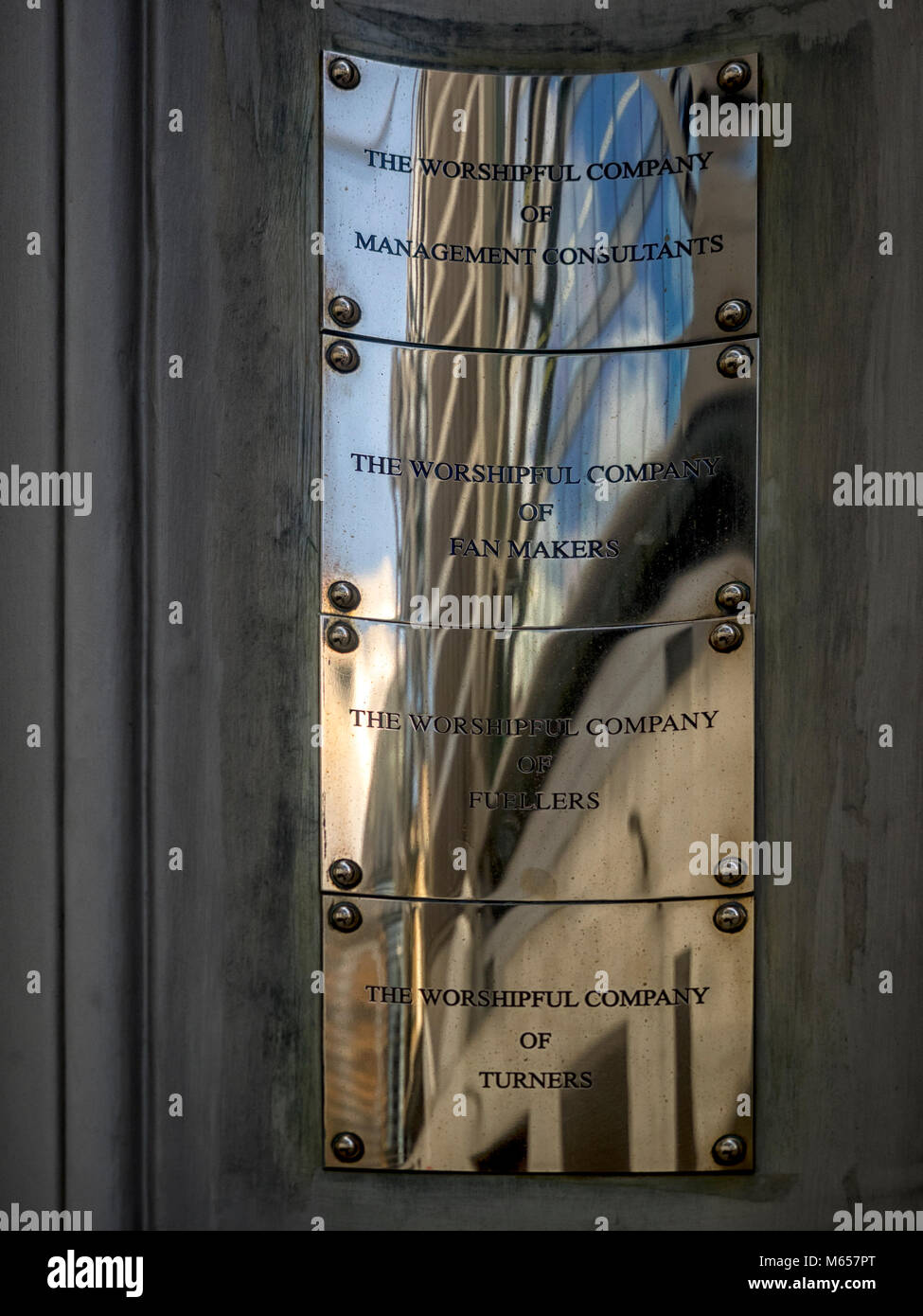LONDON, UK - FEBRUARY 18, 2018:  Reflection of Office Tower in Livery Company Brass Name Plate in Dowgate Hill Stock Photo
