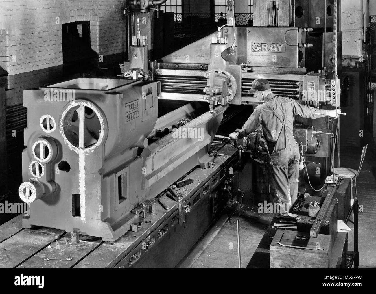 1930s 1940s 1950s MAN WORKING WITH HEAVY MACHINERY IN MANUFACTURING FACTORY - i3895 HAR001 HARS OCCUPATION SKILLS HIGH ANGLE MACHINERY CAREERS MANUFACTURING MALES MID-ADULT MID-ADULT MAN B&W BLACK AND WHITE CAUCASIAN ETHNICITY FACTORIES MACHINIST OCCUPATIONS OLD FASHIONED PERSONS Stock Photo
