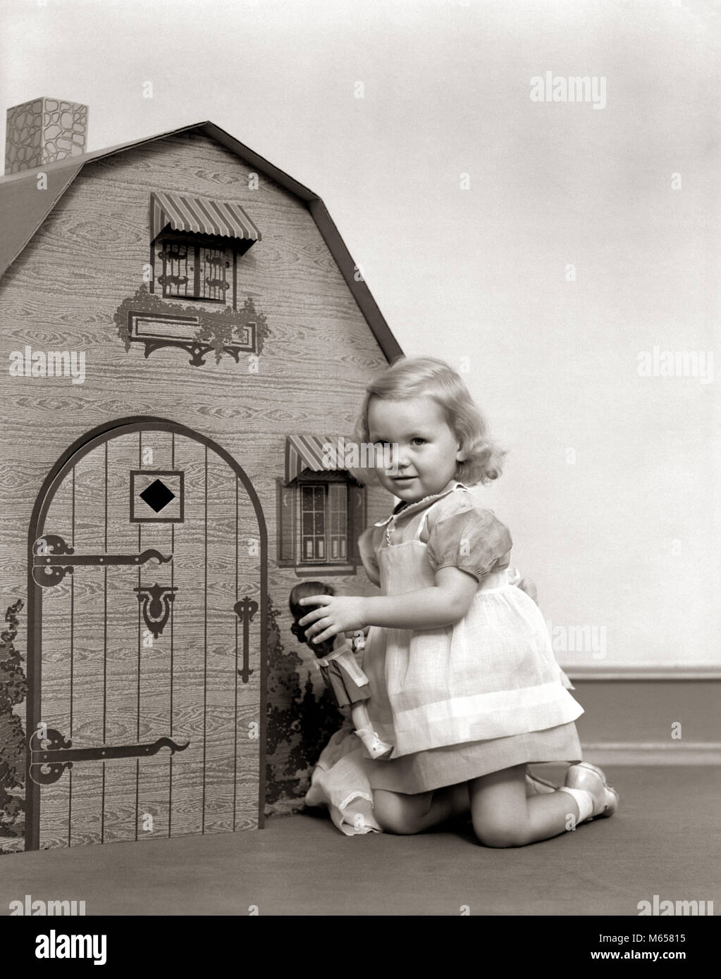 1940s LITTLE GIRL PLAYING DOLL DOLLHOUSE - j4017 HAR001 HARS ADVENTURE GROWTH IMAGINATION JUVENILES B&W BLACK AND WHITE CAUCASIAN ETHNICITY LOOKING AT CAMERA OLD FASHIONED PLAY HOUSE Stock Photo
