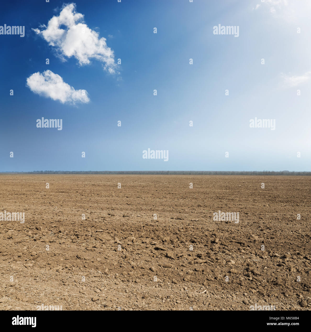 black plowed agriculture field and blue sky with clouds Stock Photo - Alamy