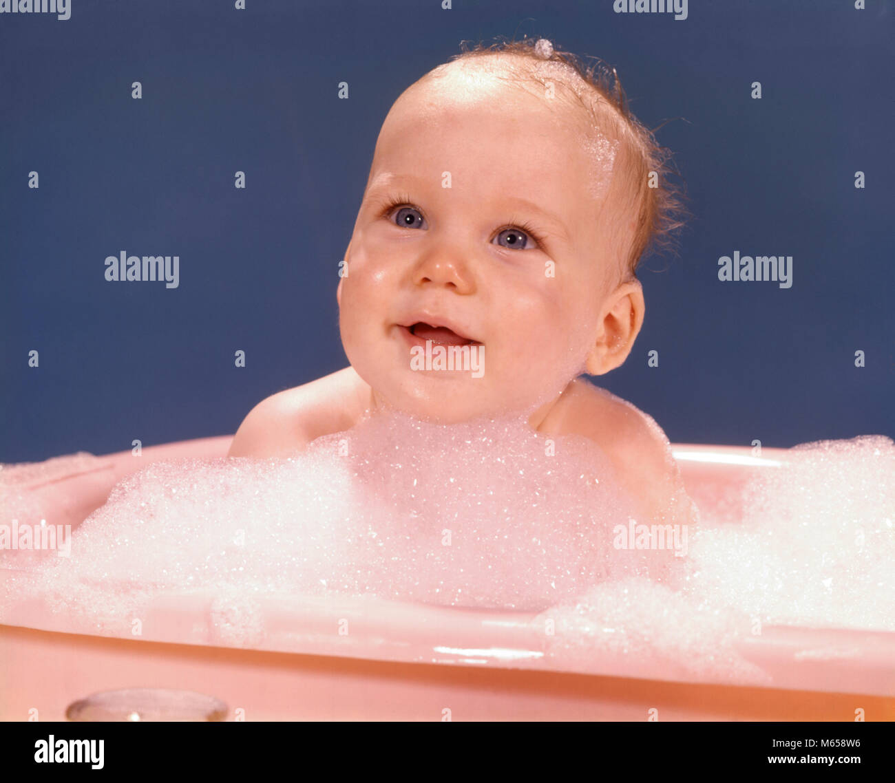 1970s HAPPY SMILING BABY BATHING IN PINK PLASTIC BATHTUB SURROUNDED BY SOAP SUDS kb3381 HAR001