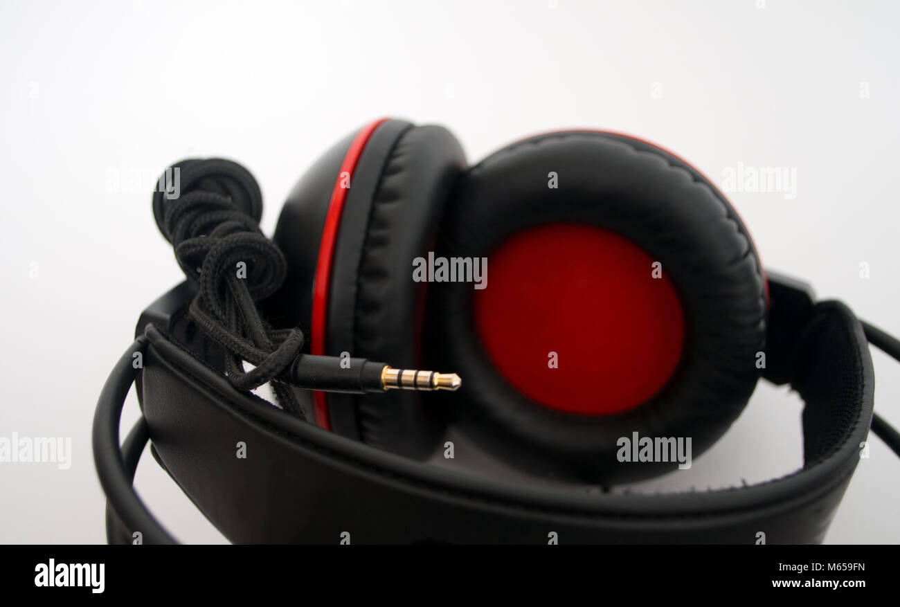 Black and red headphones on white background Stock Photo - Alamy