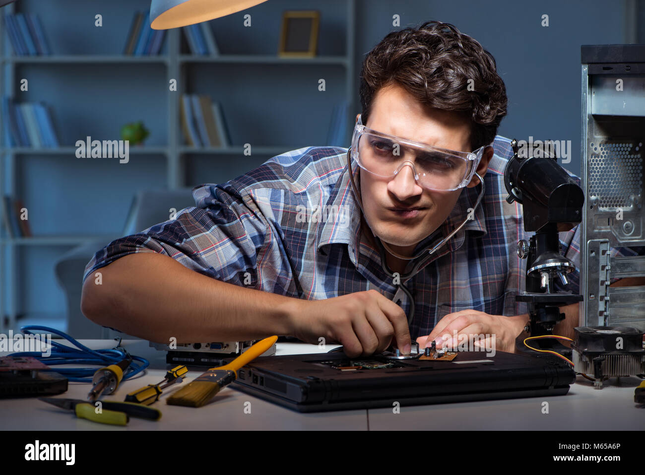 Computer repair concept with man inspecting with stethoscope Stock