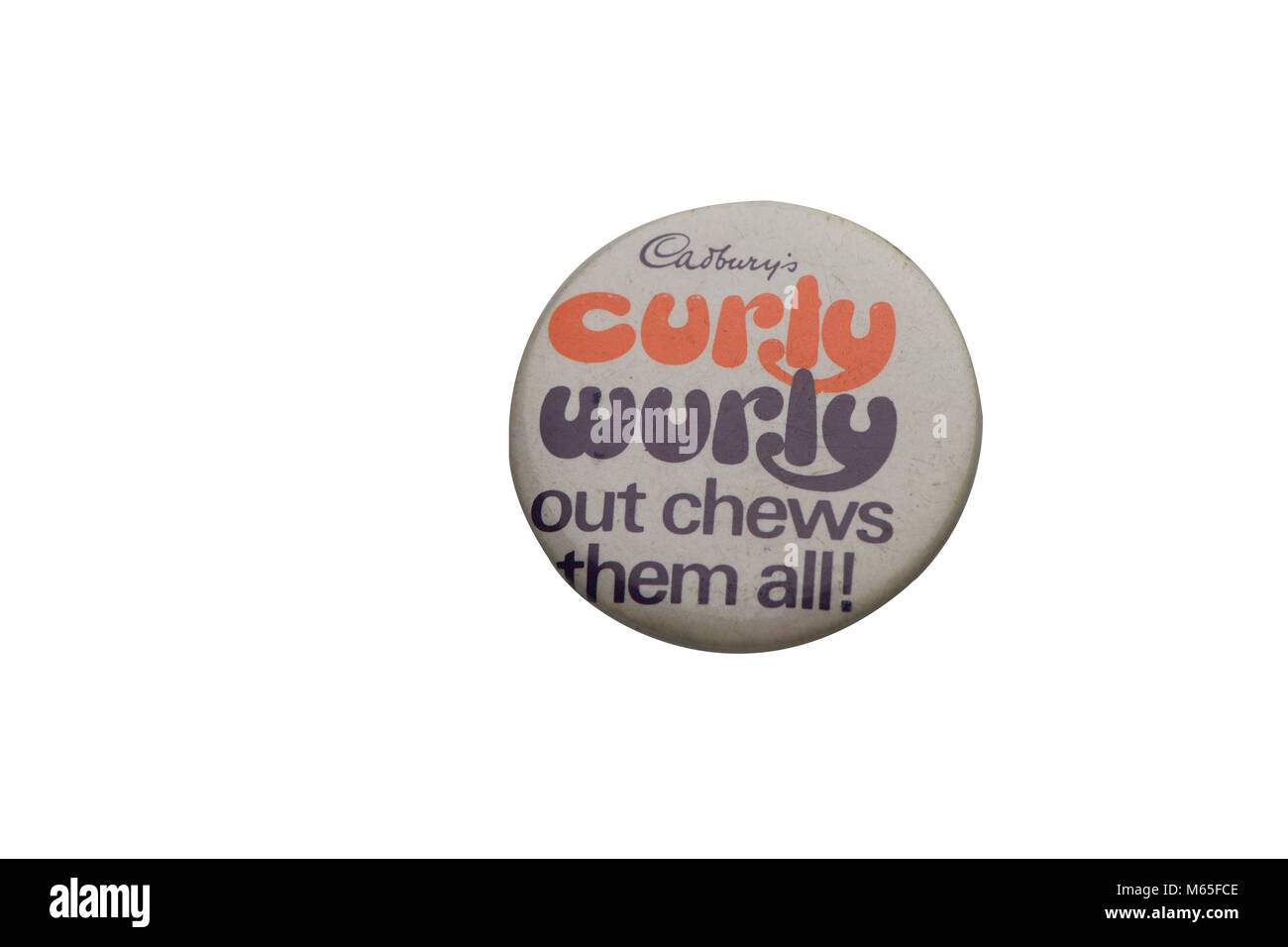 A 1970s era Curly Wurly out chews them all tin badge collectable on a white background. Stock Photo