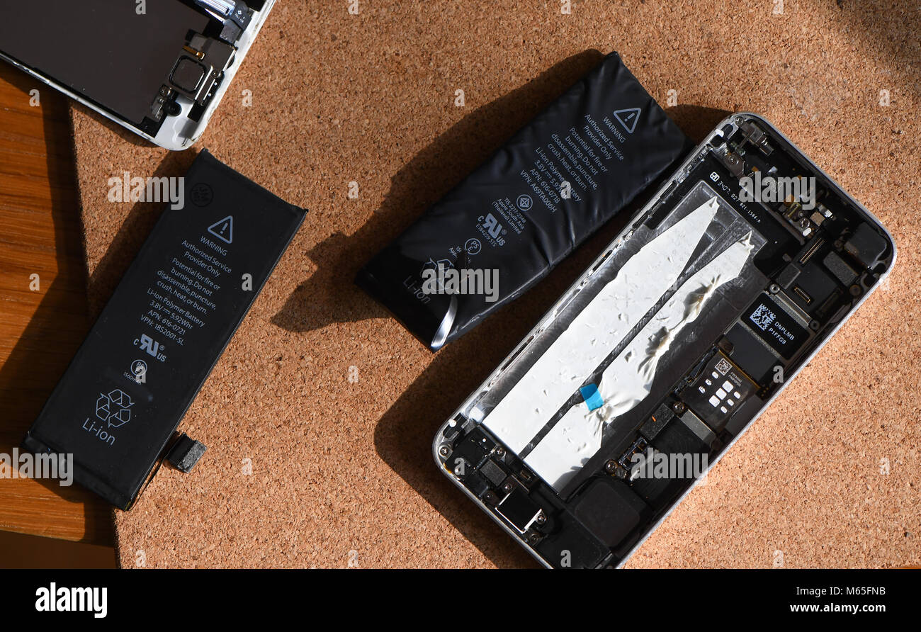 Home DIY replacement of a iPhone 5s battery showing phone opened with new  and old battery and internals of phone Stock Photo - Alamy