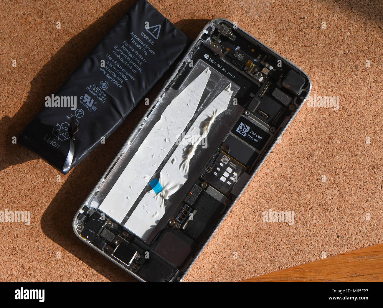 Home DIY replacement of a iPhone 5s battery showing phone opened with new  and old battery and internals of phone Stock Photo - Alamy