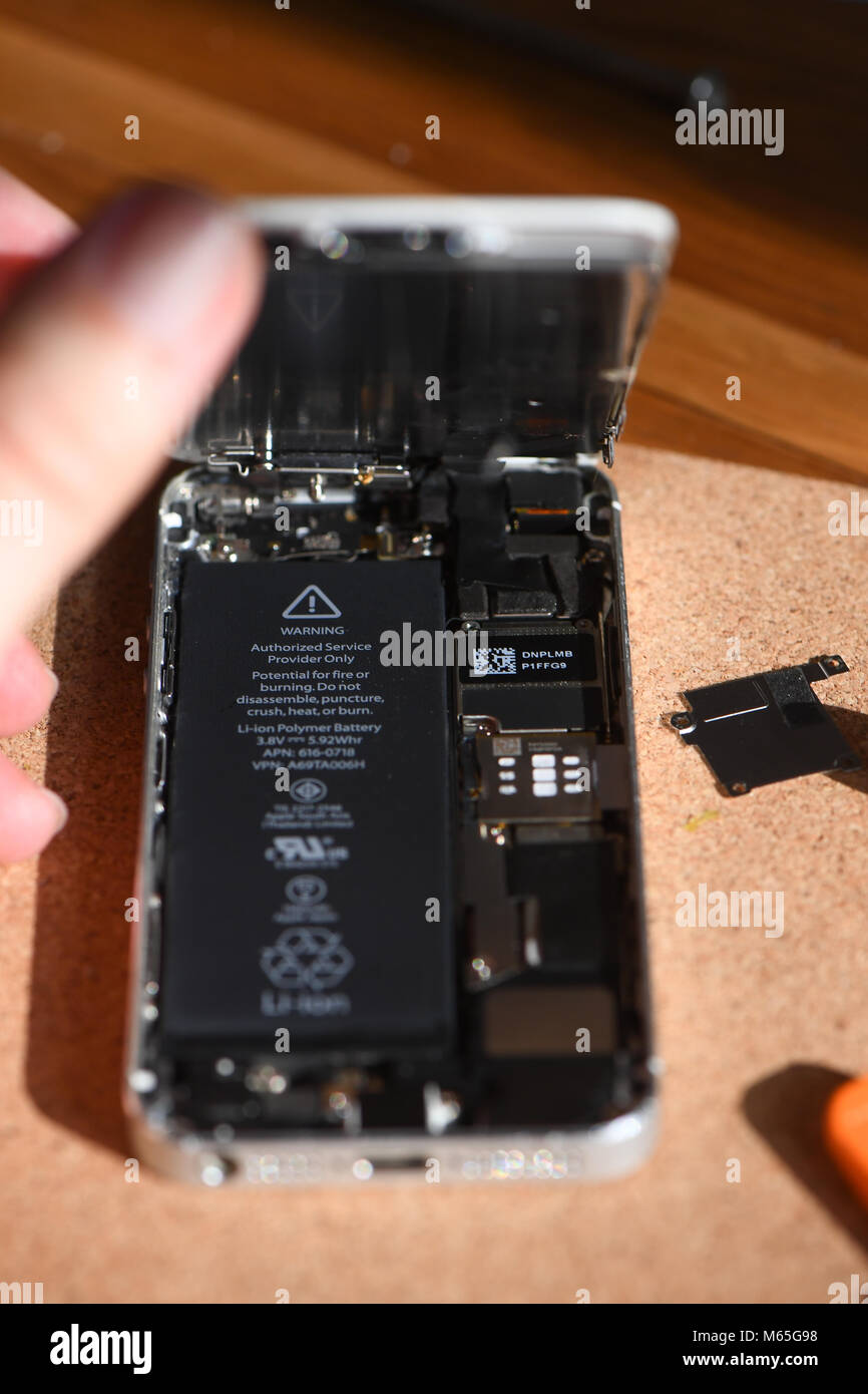 Home DIY replacement of a iPhone 5s battery showing phone opened with new  and old battery and internals of phone Stock Photo - Alamy