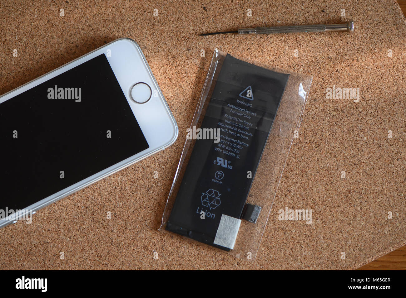 Home DIY replacement of a iPhone 5s battery showing phone opened with new  and old battery and internals of phone Stock Photo - Alamy