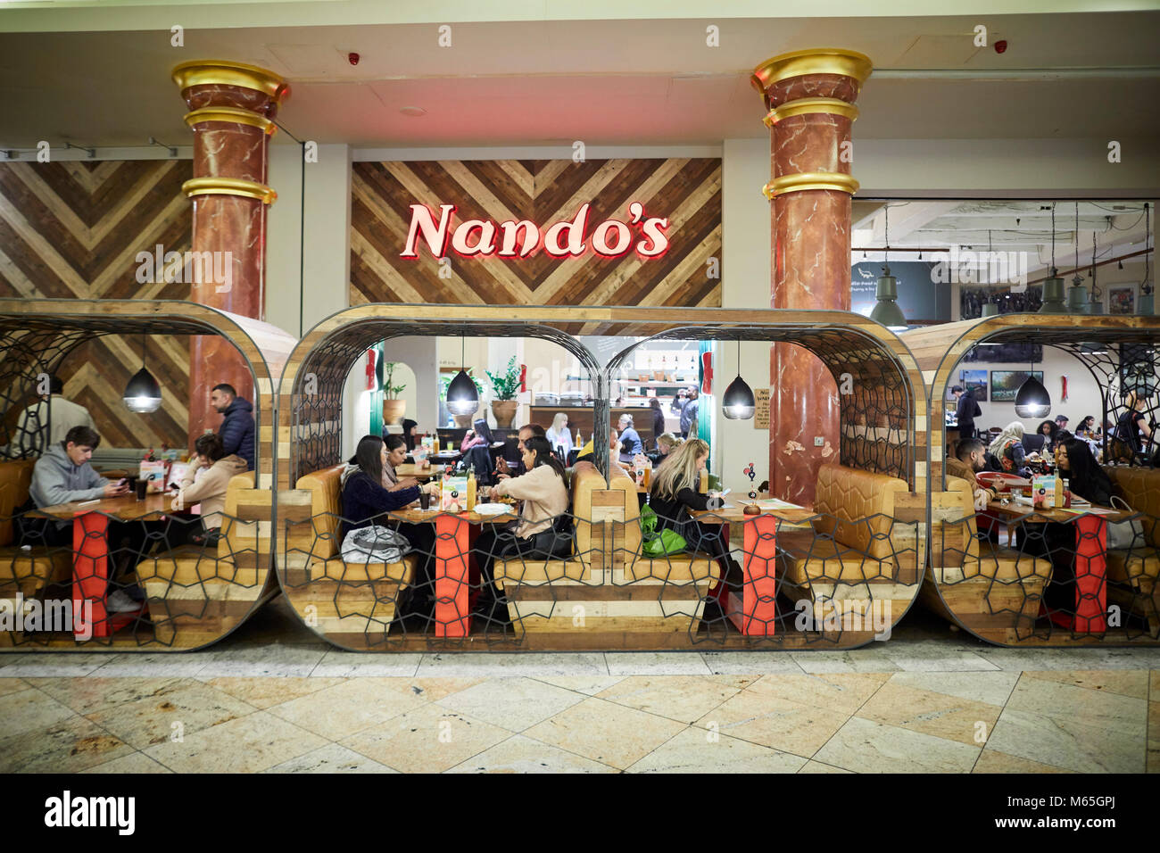South Africa. Founded, Portuguese style chicken Nando's restaurant seats booths at their Trafford Centre outlet Stock Photo