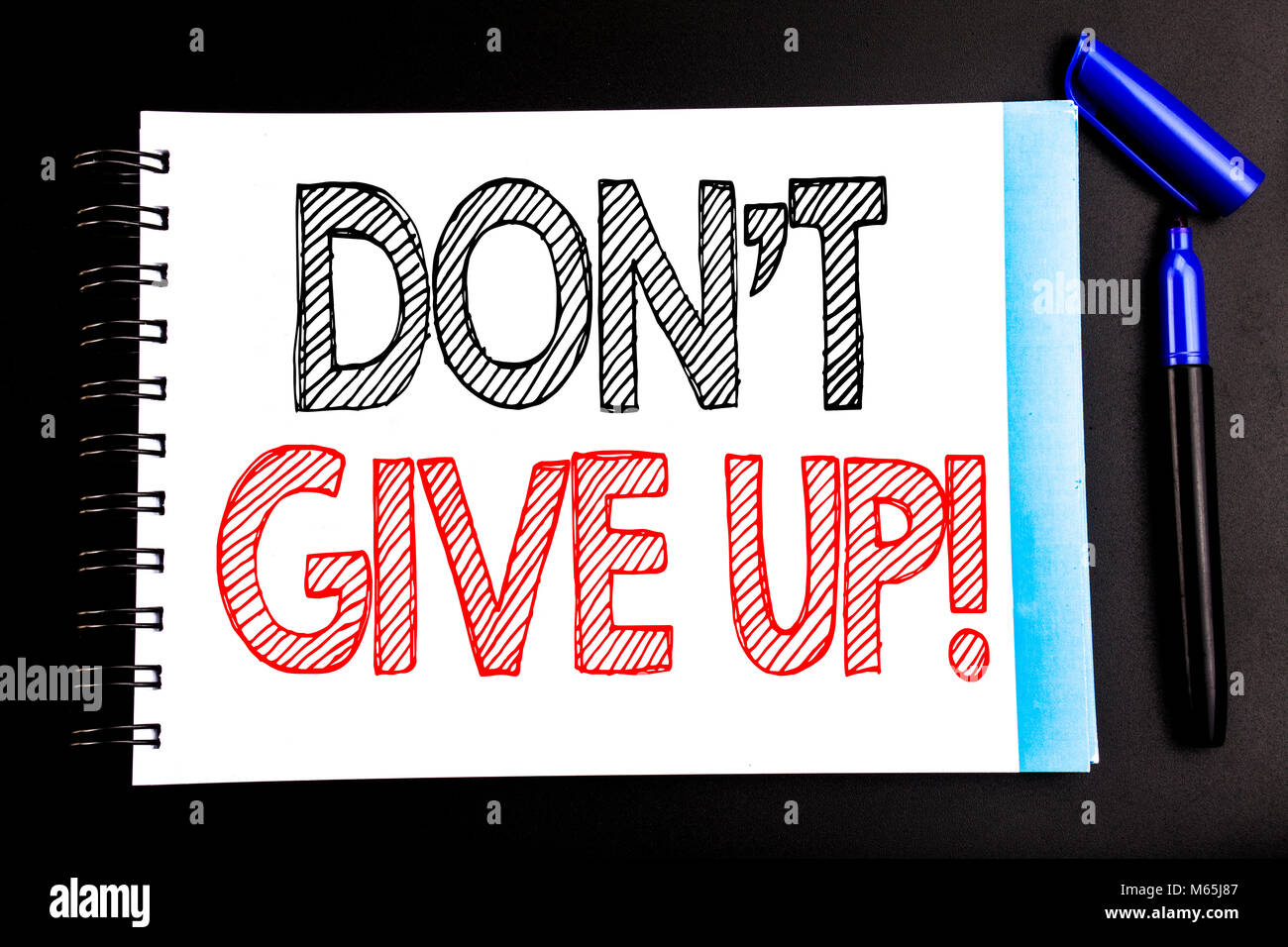 Handwritten text showing Don t Give Up. Business concept writing for Motivation Determination, Written on notepad paper, black background with space o Stock Photo