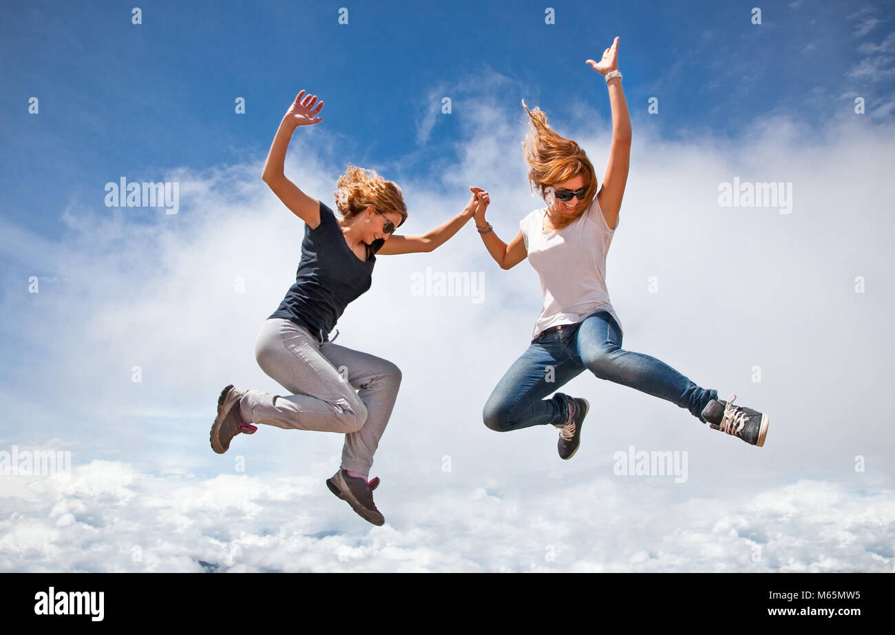 Two beautiful young woman jumping together in summer sunny day. Himalayas , Nepal. Stock Photo