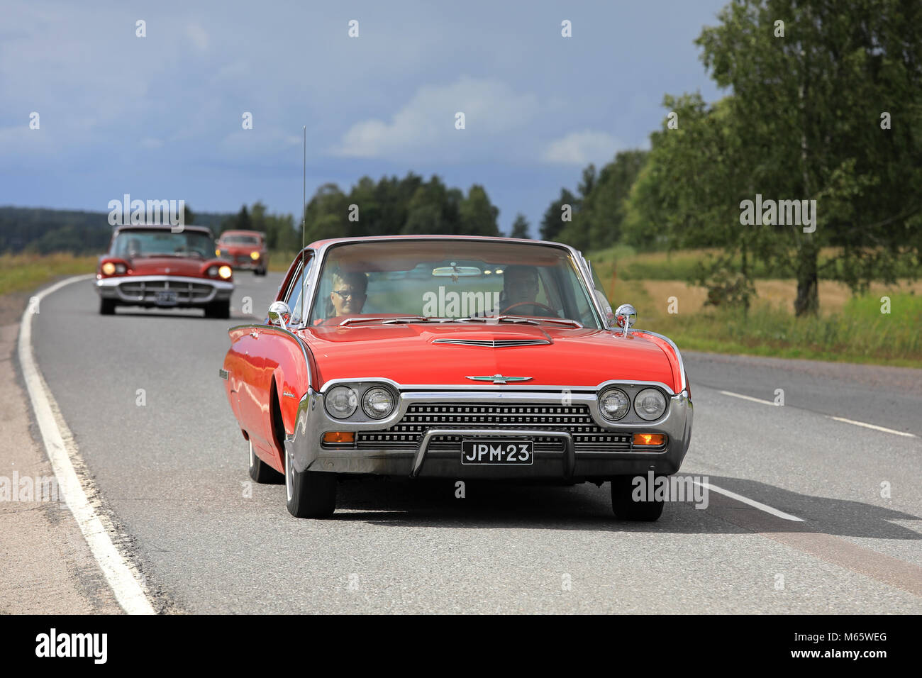 SOMERO, FINLAND - AUGUST 5, 2017: Red third generation (1961-1963) Ford Thunderbird classic car moves along rural highway on Maisemaruise 2017 car cru Stock Photo