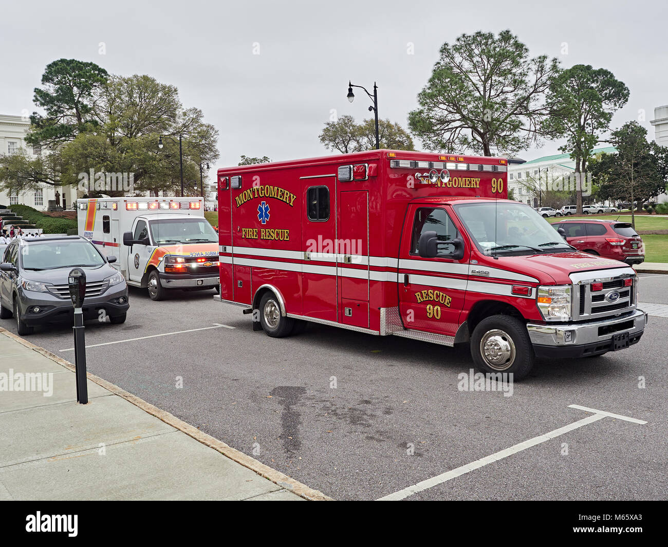 Fire Rescue paramedic ambulance with a Haynes Ambulance parked behind responding to a medical emergency in Montgomery Alabama, USA. Stock Photo