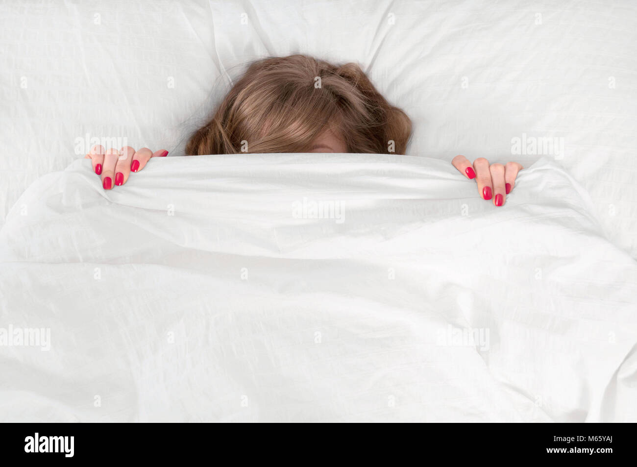 Young Woman Hiding Under Blanket High Resolution Stock Photography and