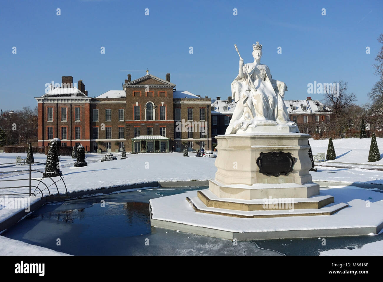 Front view of Kensington Palace and Queen Victoria statue in London on a cold winter day with snow from the Beast from the East cold spell in 2018 Stock Photo