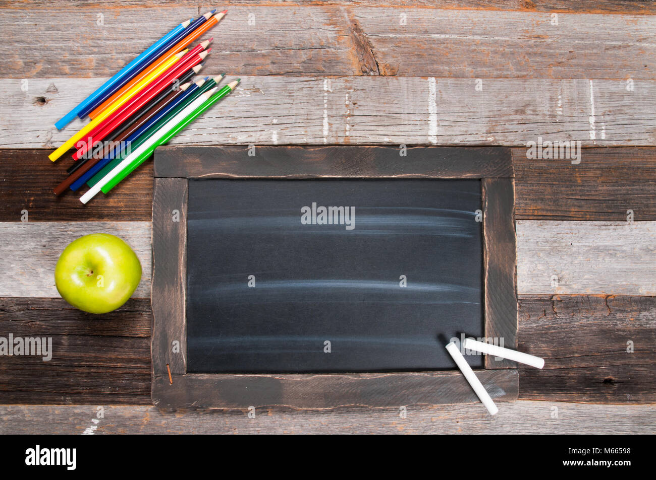 School supplies and chalkboard on wooden background. Back to school