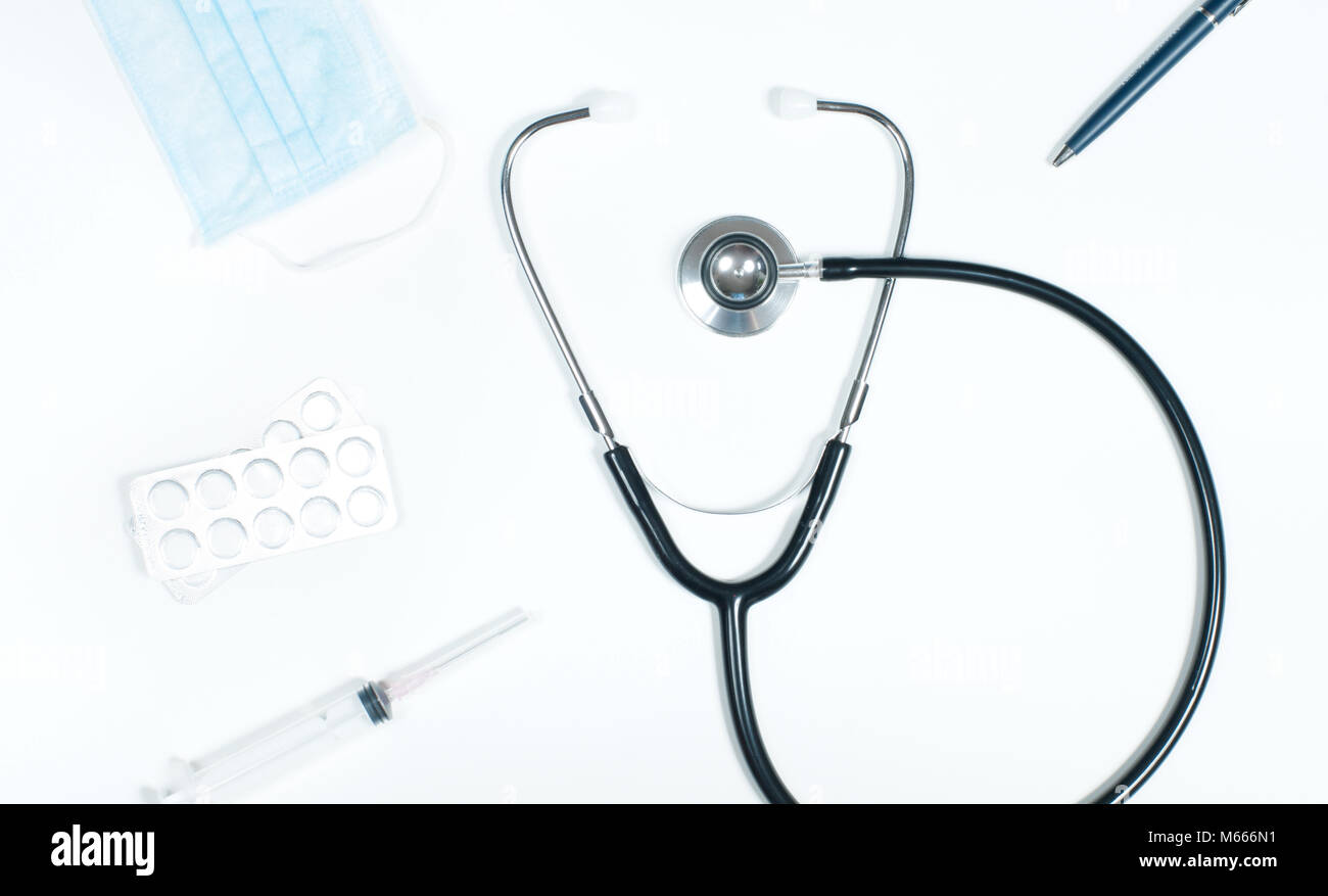 Workplace of doctor - stethoscope, medical items and pills on desk ...