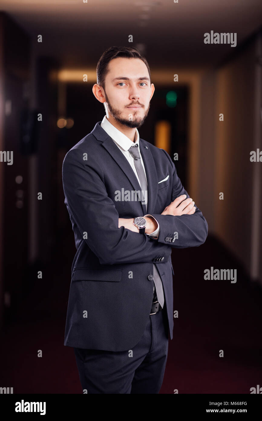 happy businessman with arms crossed standing in office Stock Photo - Alamy