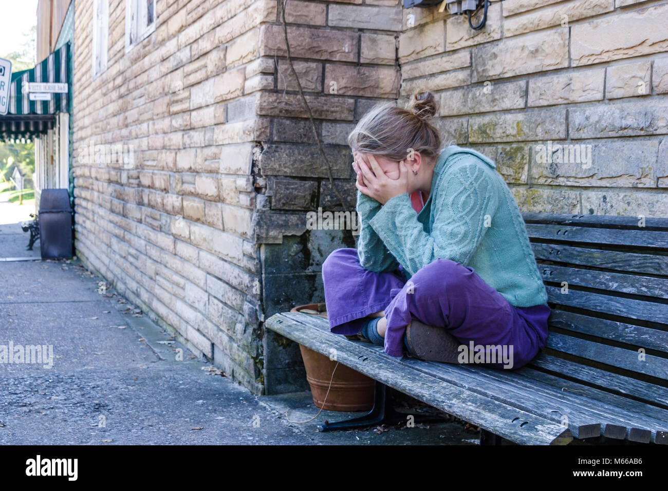 West Virginia,Appalachia Fayette County,Fayetteville,adult adults woman women female lady,holds head in hand,hands,bench,worried,stressed,emotional,al Stock Photo