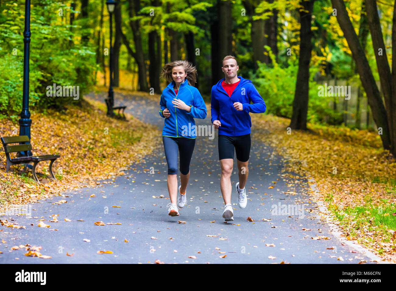 Healthy lifestyle - woman and man running in city park Stock Photo