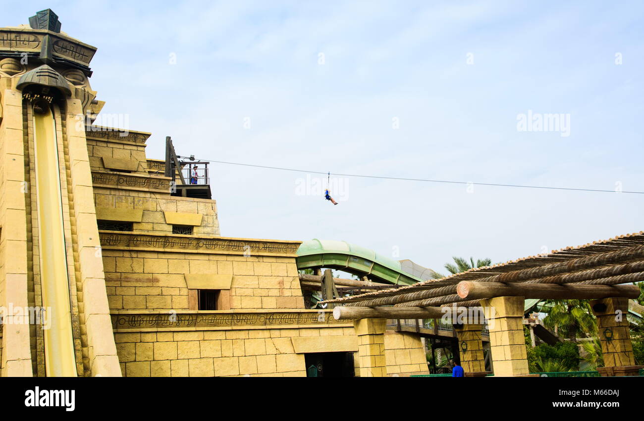 Dubai, United Arab Emirates - February 24, 2018: Tourist on the zip line in Atlantis water park on the Palm Jumeirah island in the UAE Stock Photo