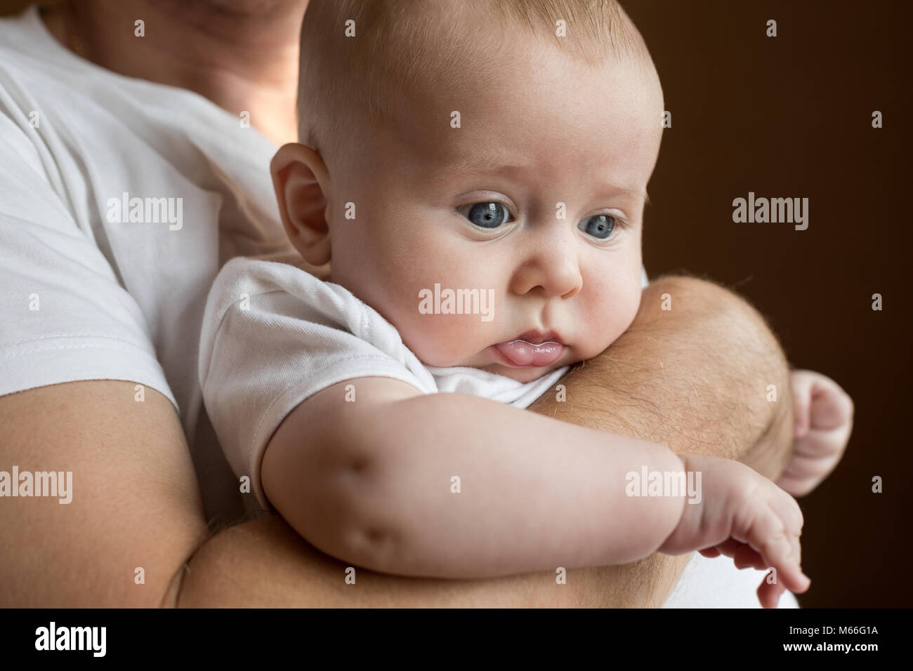 Father holding baby son at home at the day time. Concept of united family. Stock Photo