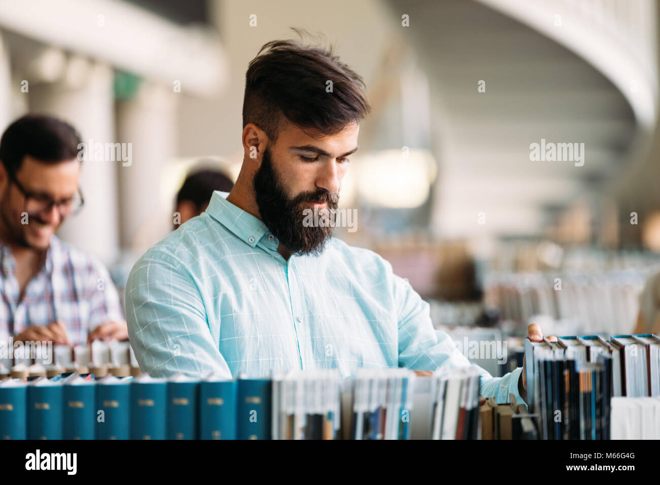 Portrait of young male student in library Stock Photo - Alamy