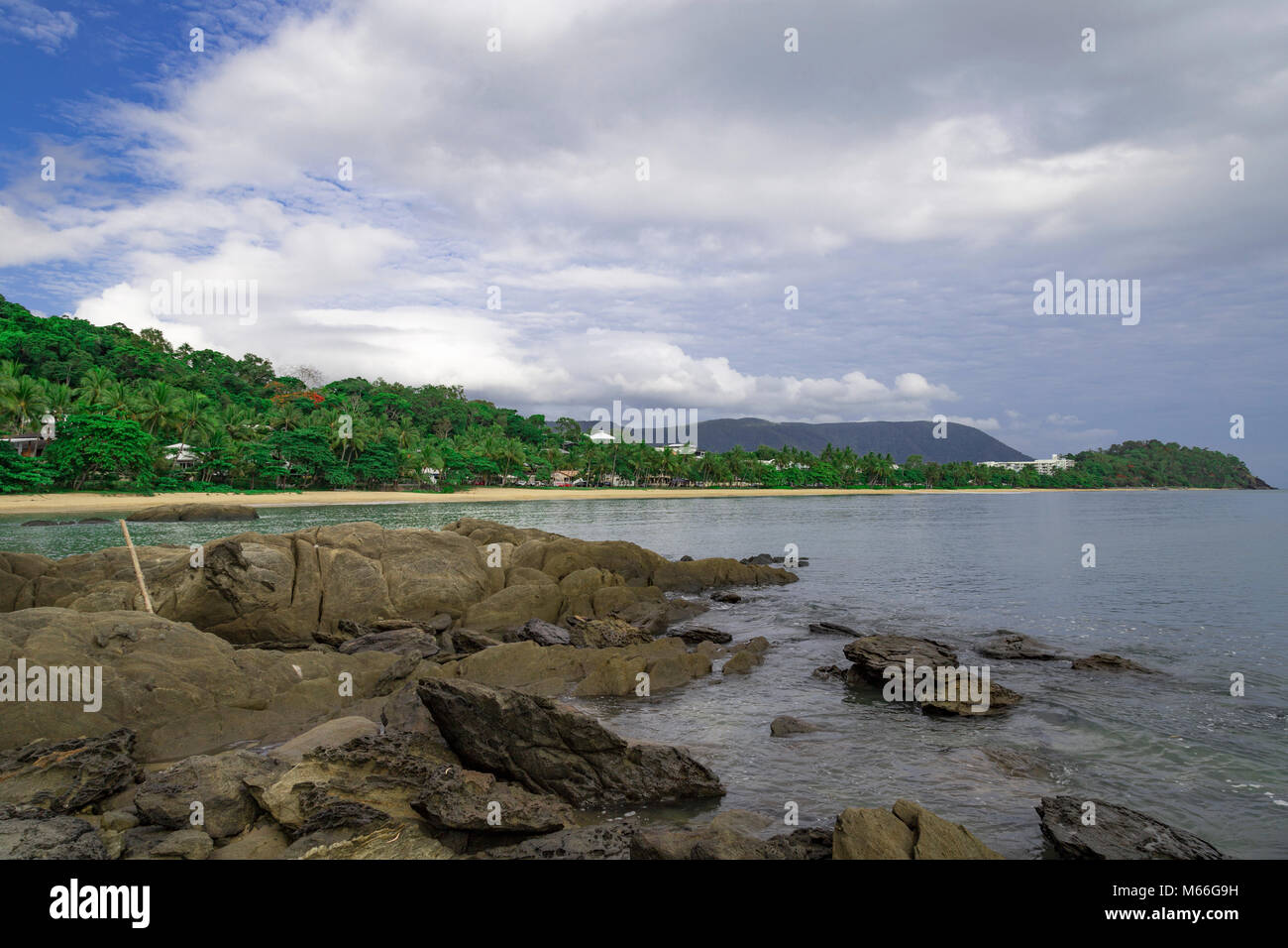 Just north of Cairns is Trinity Beach in far North Queensland Australia. Beautiful view of the area with rocks in the foreground. Stock Photo