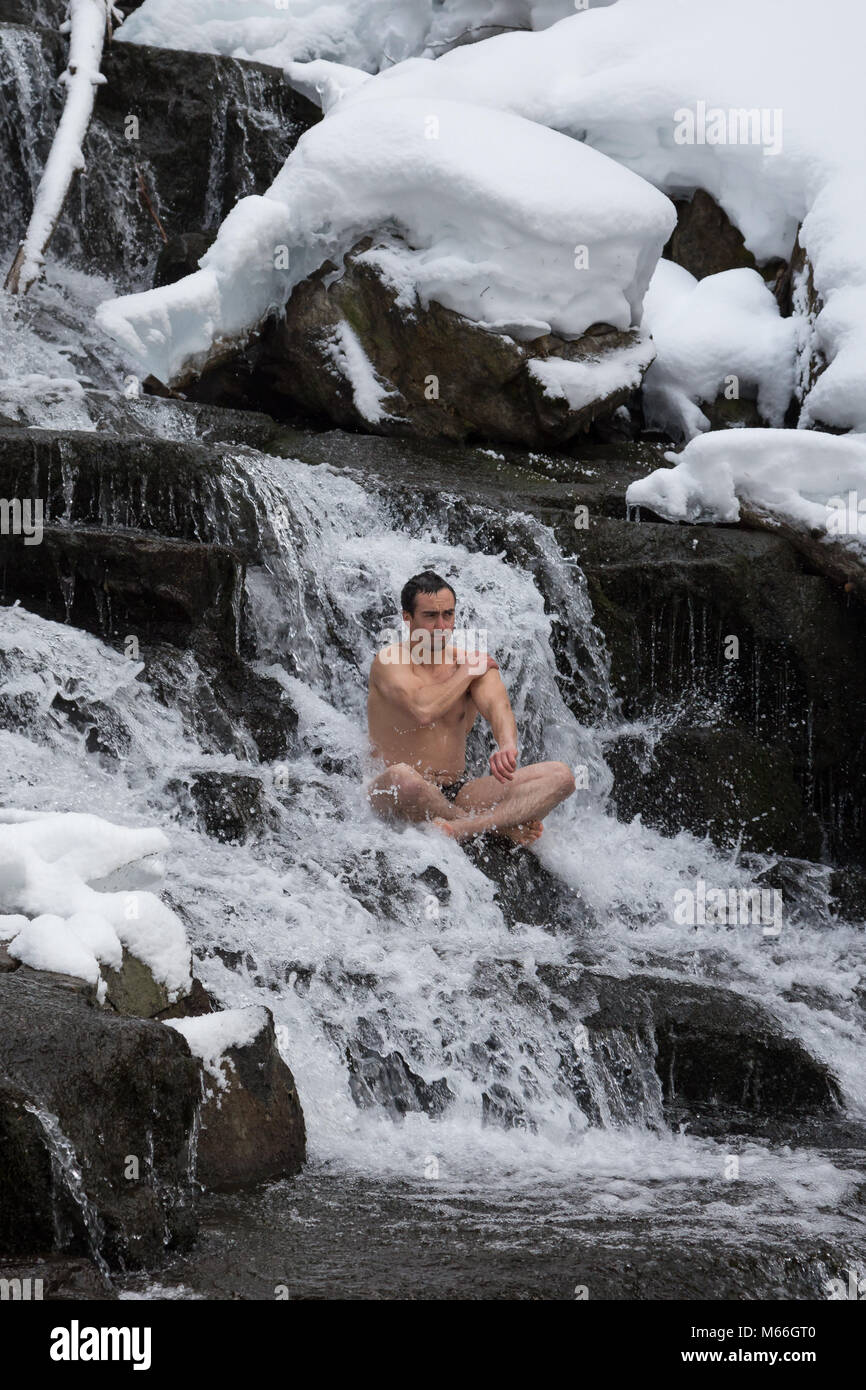 https://c8.alamy.com/comp/M66GT0/a-male-is-practicing-cold-water-immersion-under-the-beautiful-waterfall-M66GT0.jpg