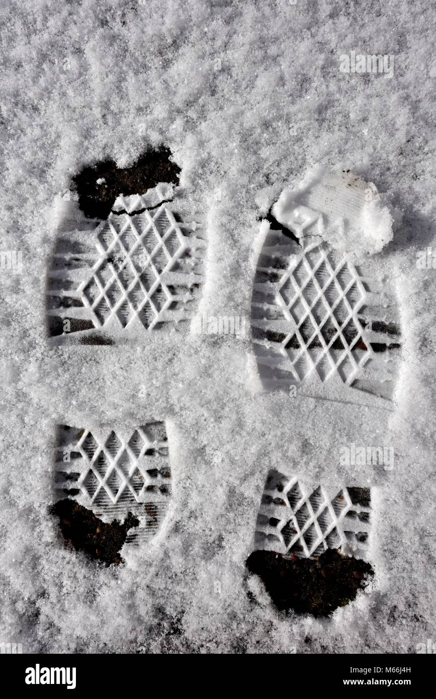 Two boot prints footprints in the snow Stock Photo - Alamy