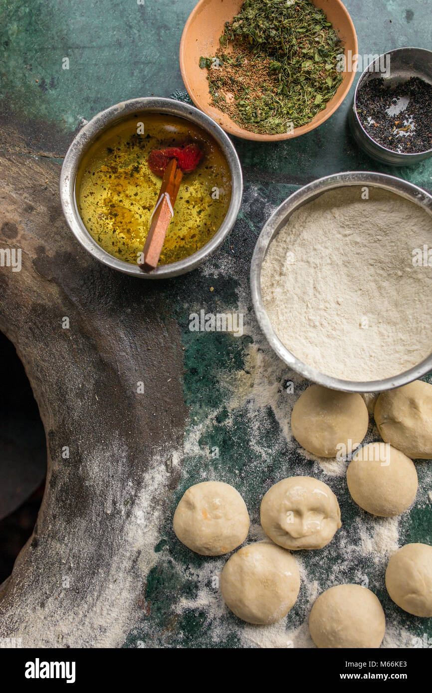 Ingredients for tandoori naan or roti - indian flat bread baked in clay oven. Oil, dough, flour and spices on the top of tandoori oven Stock Photo