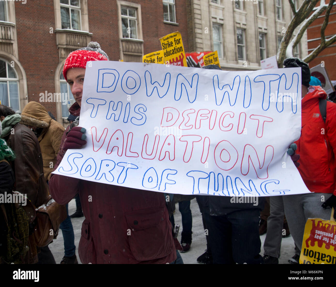 University staff and students demonstrated in Central London . A protester holds a poster saying 'Down with deficit valuation' Stock Photo