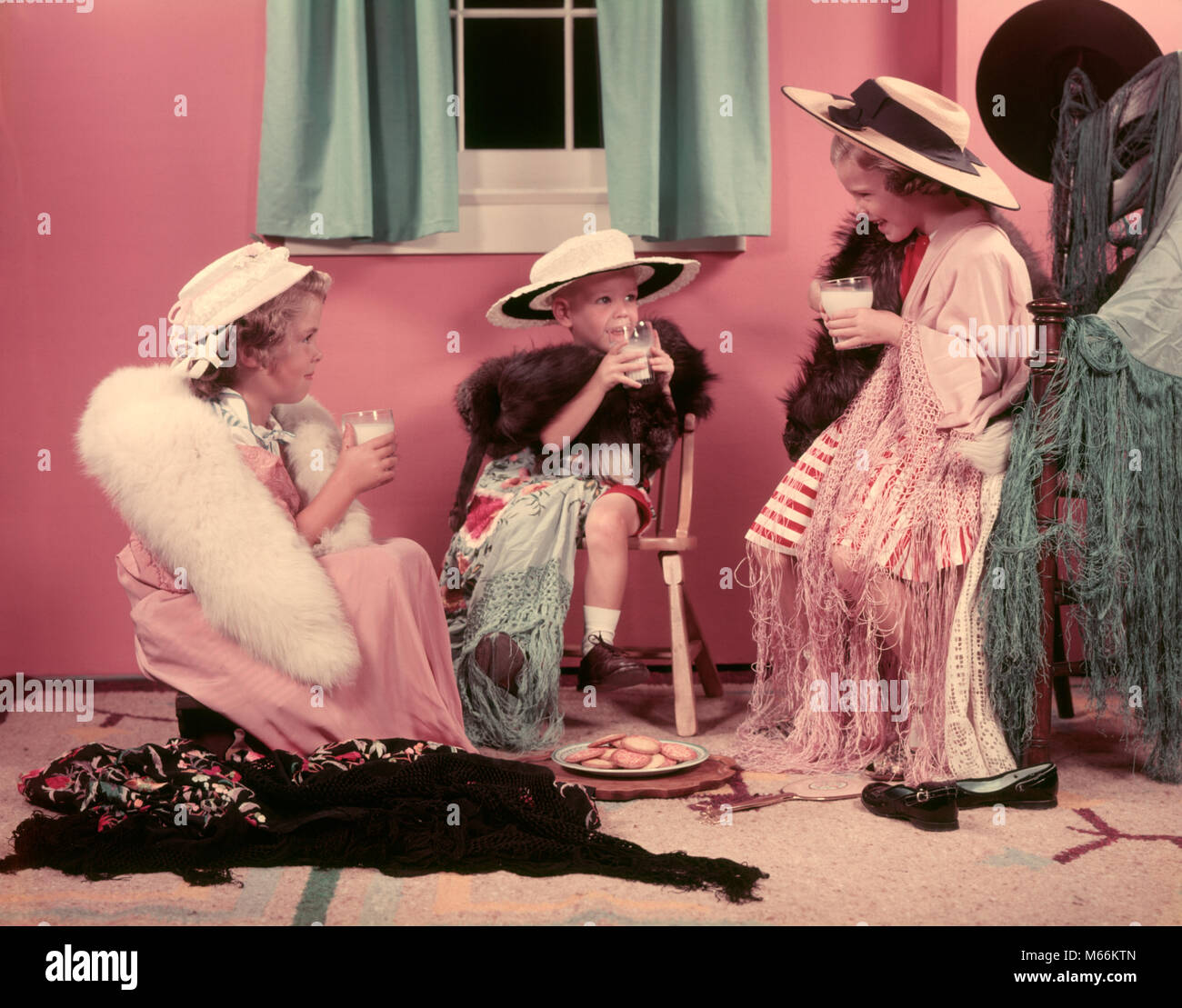 1950s THREE LITTLE GIRLS DRINKING MILK PLAYING ADULT DRESS UP IN OLD CLOTHES AND HATS - kf1478 HAR001 HARS FRIENDSHIP HALF-LENGTH GROWN-UP ROLE COOKIES INDOORS SIBLINGS SISTERS NOSTALGIA TOGETHERNESS 3-4 YEARS 5-6 YEARS HAPPINESS NOURISH BEVERAGE PRETEND STYLES FLUID GROWTH SIBLING CONNECTION STOLE FASHIONS COOPERATION IMAGINATION NOURISHMENT SMALL GROUP OF PEOPLE MAKE-BELIEVE JUVENILES MALES SCARVES CAUCASIAN ETHNICITY DRESS UP DRESSING UP OLD FASHIONED PERSONS Stock Photo