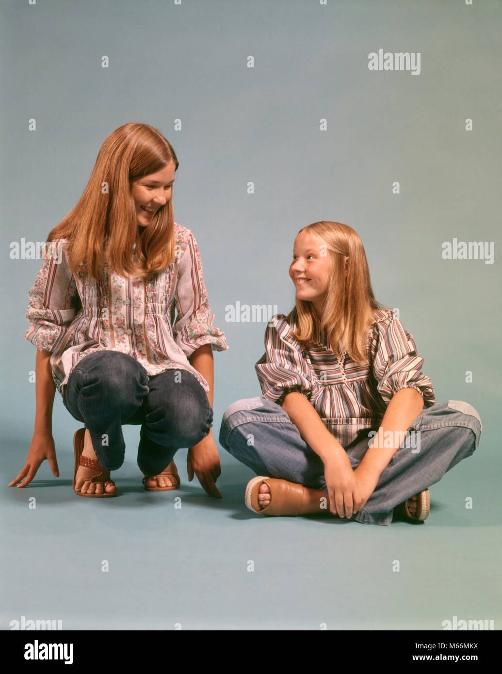 1970s TWO TEEN GIRLS SISTERS WEARING BLUE JEANS DENIM PEASANT SHIRTS SITTING AND KNEELING SMILING LOOKING AT EACH OTHER - kj6514 HAR001 HARS STUDIO SHOT HEALTHINESS HOME LIFE COPY SPACE PEOPLE CHILDREN FRIENDSHIP HALF-LENGTH ADOLESCENT TEENAGE GIRL INDOORS SIBLINGS DENIM SISTERS NOSTALGIA TOGETHERNESS 13-15 YEARS 16-17 YEARS KNEELING HAPPINESS LEISURE STYLES AND SHIRTS SIBLING SMILES JOYFUL FASHIONS LONG HAIR TEENAGED BLUE JEANS JUVENILES PEASANT SANDALS CAUCASIAN ETHNICITY EACH OTHER OLD FASHIONED PERSONS Stock Photo