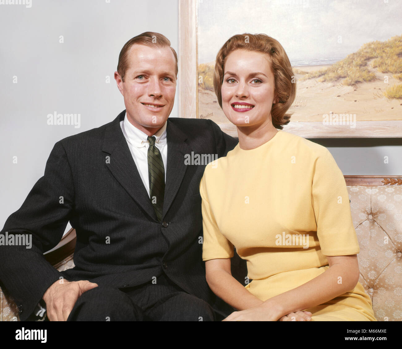 1960s HAPPY COUPLE SITTING ON SOFA MAN 