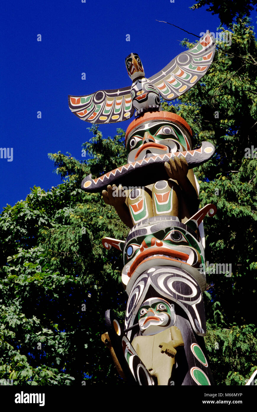 1990s TOTEM POLE IN STANLEY PARK VANCOUVER BRITISH COLUMBIA CANADA - kr104076 KRU001 HARS PAINTED CONNECTION CREATIVITY IMAGINATION NATIVE AMERICAN PROVINCE SMALL GROUP OF ANIMALS SYMBOLIC POLYCHROME SCULPTURES TOTEM WILDLIFE BC BRITISH COLUMBIA INDIGENOUS INDIGENOUS PEOPLE MONUMENTAL MONUMENTAL SCULPTURES OLD FASHIONED PACIFIC NORTHWEST COAST PROVINCES STANLEY PARK TOTEMS TRAVEL CANADA VANCOUVER Stock Photo