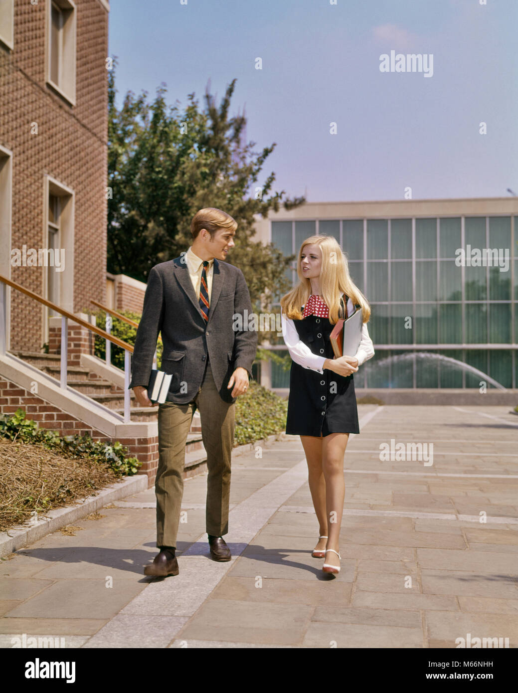 1960s 1970s YOUNG ADULT STUDENT COUPLE WALKING SIDE BY SIDE ON CAMPUS GIRL IN MINIDRESS BOY IN SUIT TIE - ks5838 HAR001 HARS STYLE BLOND YOUNG ADULT MINI CAUCASIAN LIFESTYLE CAMPUS FEMALES COPY SPACE FRIENDSHIP FULL-LENGTH TEENAGE GIRL TEENAGE BOY COUPLES NOSTALGIA TOGETHERNESS 20-25 YEARS STYLES UNIVERSITIES 18-19 YEARS HIGH SCHOOL CONNECTION HIGH SCHOOLS HIGHER EDUCATION FASHIONS TEENAGED COLLEGES COED MALES YOUNG ADULT MAN YOUNG ADULT WOMAN CAUCASIAN ETHNICITY MINI DRESS MINI-DRESS OLD FASHIONED PERSONS TWO PEOPLE WITH OTHERS Stock Photo