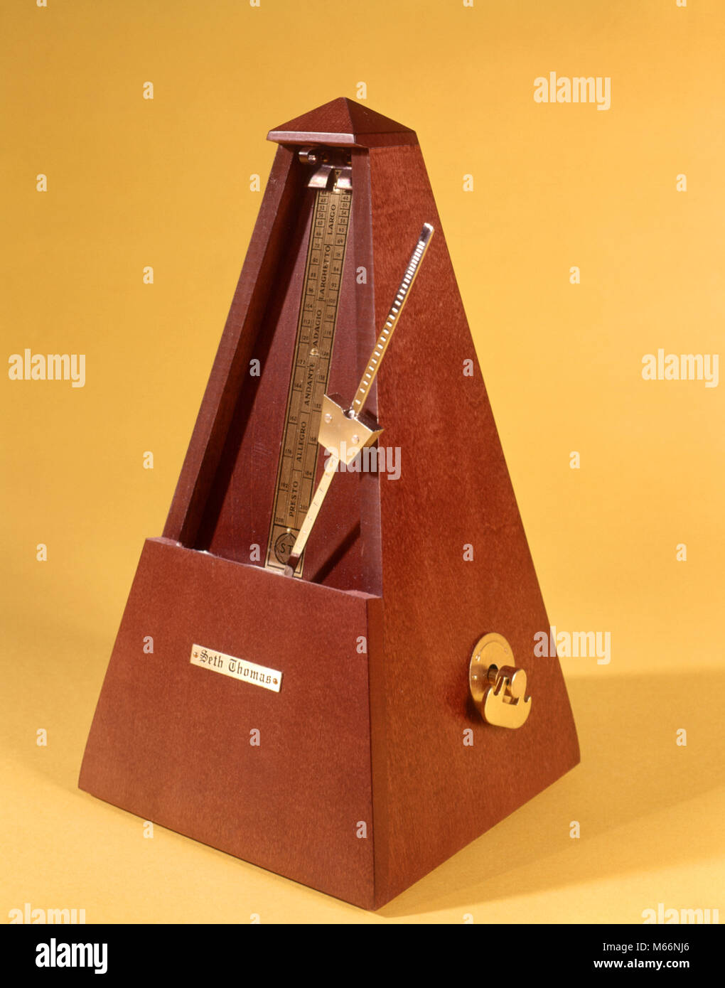 1970s WOODEN METRONOME KEEPING TIME - ks7586 HAR001 HARS BEATS BEATS PER MINUTE BPM CLICK CLICKING EVEN GADGET GIZMO KEEPING TIME KEY WIND MARKING MARKS METRICAL METRONOME OLD FASHIONED PENDULUM RATE REGULAR INTERVALS SETH THOMAS SPRING DRIVE SPRING WOUND SWINGING PENDULUM TICK TOCK TICKING TIME KEEPER TIMING TEMPO VISUAL MOTION WIND UP WOODEN STICK Stock Photo