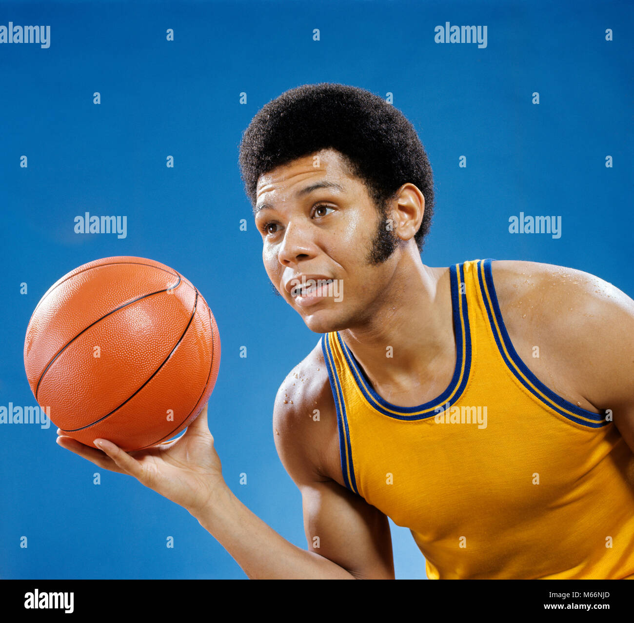 1960s 1970s AFRICAN AMERICAN MAN HOLDING BASKETBALL - ks8247 HAR001 HARS 20-25 YEARS GOALS SINGLE OBJECT HEAD AND SHOULDERS LEISURE AFRICAN-AMERICANS AFRICAN-AMERICAN EXCITEMENT RECREATION ETHNIC BLACK BLACK ETHNICITY 18-19 YEARS AFRICAN AMERICANS AFRICAN AMERICAN FACIAL HAIR HIGH SCHOOL BALL SPORT HAIRDO MALES SIDEBURNS YOUNG ADULT MAN OCCUPATIONS OLD FASHIONED PERSONS Stock Photo