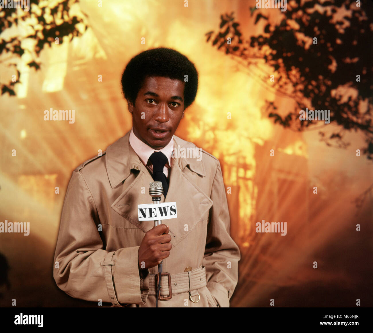 1970s AFRICAN AMERICAN MAN TV REPORTER AT SCENE OF FIRE SPEAKING TO MICROPHONE LOOKING AT CAMERA - kt2184 HAR001 HARS GROWN-UP RISK SPEAK WARM ENTERTAINMENT NOSTALGIA SADNESS EYE CONTACT 20-25 YEARS 25-30 YEARS DISASTER AFRICAN-AMERICAN COMPOSITE EXCITEMENT ETHNIC BLACK AFRO-AMERICAN AFRICAN AMERICAN ELECTRIC APPLIANCE COMMUNICATE REPORTING COMMUNICATIONS TRENCH COAT MALES MID-ADULT MID-ADULT MAN NEWSMAN LOOKING AT CAMERA OCCUPATIONS OLD FASHIONED PERSONS Stock Photo
