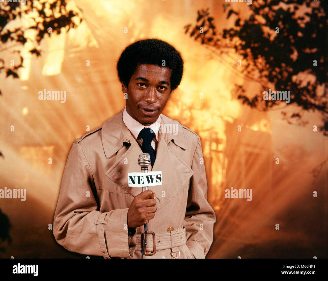 1970s AFRICAN AMERICAN TV NEWSMAN WEARING TRENCH COAT LOOKING AT CAMERA HOLD MICROPHONE REPORTING AT SCENE OF RAGING HOUSE FIRE - kt2188 HAR001 HARS STYLE FEAR COMMUNICATION BURNING CAREER YOUNG ADULT INFORMATION FLAME LIFESTYLE SPEED RAINCOAT HEAT GROWNUP ONE PERSON ONLY COMMUNICATING HALF-LENGTH BURN INSPIRATION GROWN-UP CHARACTER RISK PROFESSION WARM ENTERTAINMENT CONFIDENCE NOSTALGIA EYE CONTACT 20-25 YEARS 25-30 YEARS SUCCESS PERFORMING ARTS OCCUPATION ADVENTURE BROADCASTING STYLES CUSTOMER SERVICE TRENCH AFRICAN-AMERICANS COURAGE AFRICAN-AMERICAN CAREERS EXCITEMENT KNOWLEDGE ETHNIC BLACK Stock Photo