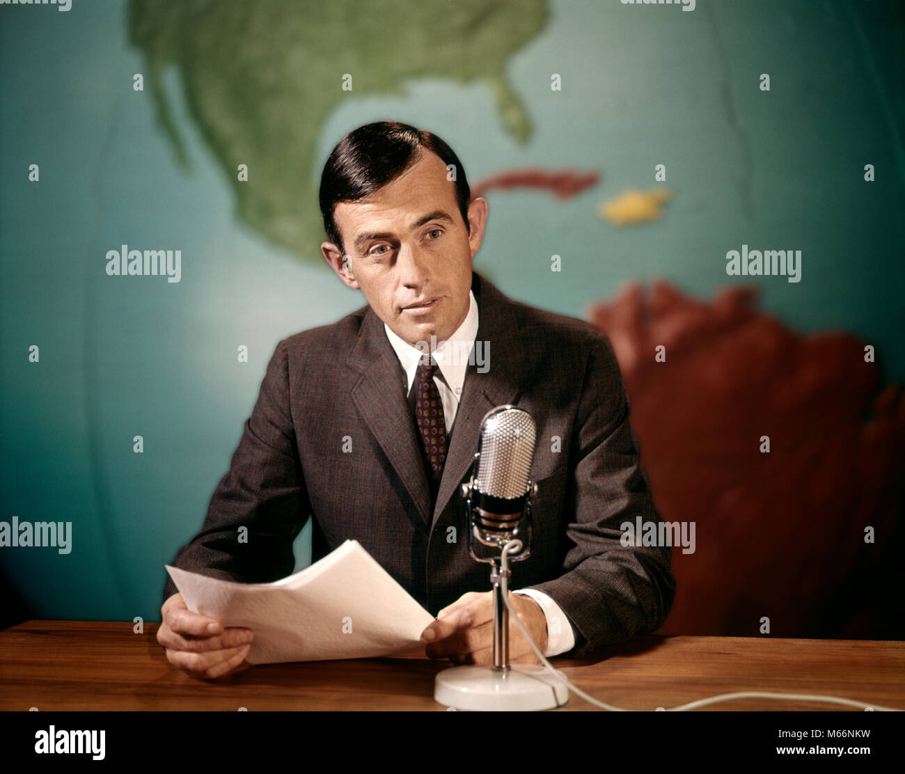 1960s NEWSMAN NEWS ANCHOR READING NEWS FROM PAPERS SPEAKING INTO MICROPHONE LOOKING AT CAMERA - kt7200 HAR001 HARS CAREER TEAMWORK INFORMATION CAUCASIAN ANCHOR LIFESTYLE SPEED JOBS STUDIO SHOT ONE PERSON ONLY COMMUNICATING HALF-LENGTH INSPIRATION SPEAK INDOORS PROFESSION ENTERTAINMENT CONFIDENCE NOSTALGIA 25-30 YEARS 30-35 YEARS FREEDOM SKILL OCCUPATION SKILLS CAREERS KNOWLEDGE PRIDE AUTHORITY COMMUNICATE IDEAS COMMUNICATIONS MALES MID-ADULT MID-ADULT MAN NEWSMAN PRECISION CAUCASIAN ETHNICITY COMMENT COMMENTATOR COMMENTS LOOKING AT CAMERA OCCUPATIONS OLD FASHIONED PERSONS Stock Photo