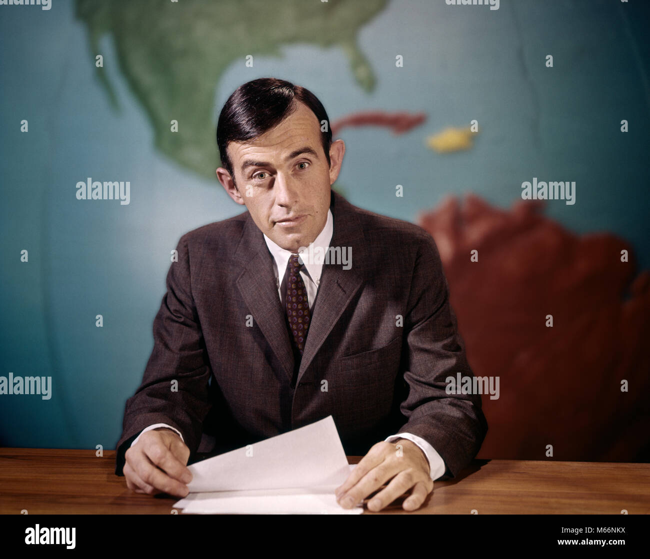 1960s NEWSMAN LOOKING AT CAMERA READING NEWS FROM PAPERS SPEAKING INTO MICROPHONE LOOKING AT CAMERA WORLD MAP BACKGROUND - kt7201 HAR001 HARS INDOORS ENTERTAINMENT NOSTALGIA 35-40 YEARS 40-45 YEARS BROADCASTING ANNOUNCER COMMUNICATE TIES COMMUNICATIONS JOURNALISM MALES MID-ADULT MID-ADULT MAN NEWSMAN CAUCASIAN ETHNICITY LOOKING AT CAMERA OCCUPATIONS OLD FASHIONED PERSONS WORKER WORKING Stock Photo