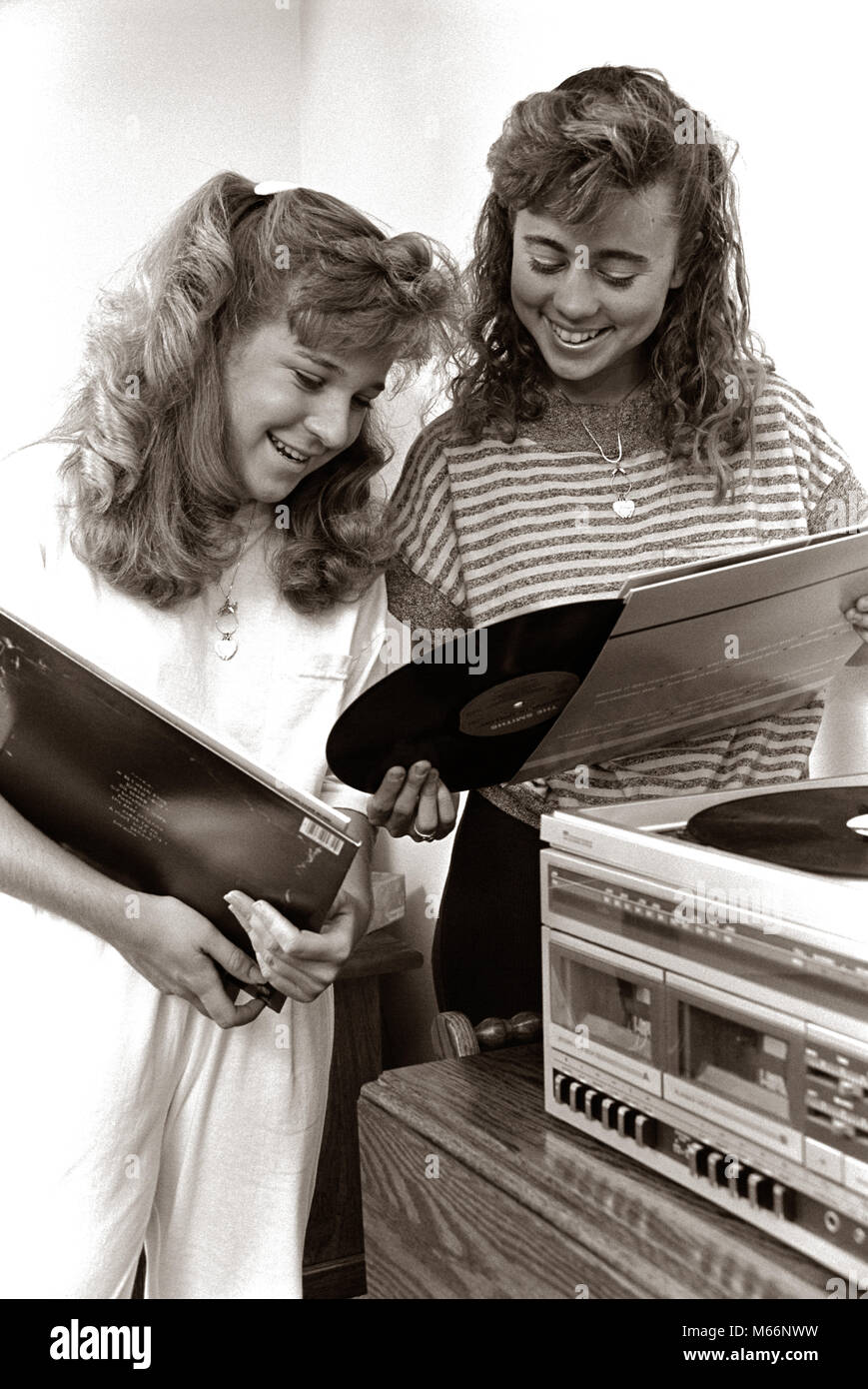 1980s 2 TEENAGE GIRLS READING VINYL RECORD ALBUM JACKET COVERS LISTENING TO LONG PLAYING PHONOGRAPH PLAYER - m11308 HAR001 HARS NOSTALGIA PLAYERS PHONOGRAPH TOGETHERNESS STEREO 13-15 YEARS 16-17 YEARS COOPERATION COMMUNICATE SLEEVES TEENAGED LP JUVENILES ALBUMS B&W BLACK AND WHITE CAUCASIAN ETHNICITY JACKETS OLD FASHIONED PERSONS RECORDINGS Stock Photo
