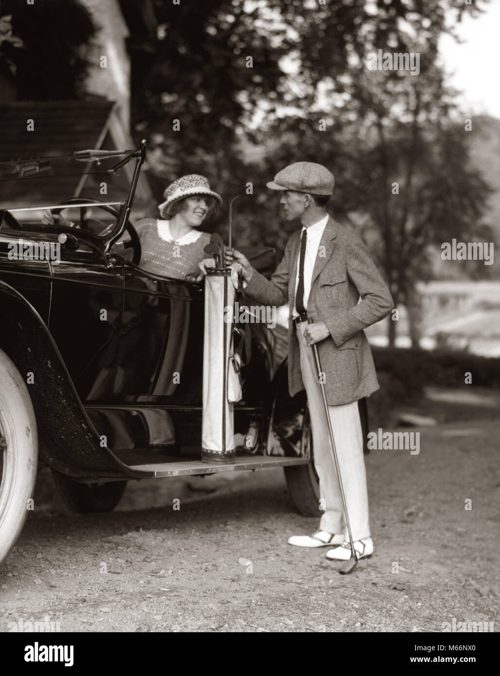 1920s COUPLE WOMAN MAN RESTING GOLF CLUBS BAG ON 1922 LINCOLN CONVERTIBLE RUNNING BOARD UPSCALE COUNTRY CLUB GOLFING LIFESTYLE - m130 HAR001 HARS RUN NOSTALGIC PAIR ROMANCE BEAUTY STYLISH SUBURBAN GOLFER OLD TIME BUSY LINCOLN RUNNER OLD FASHION AUTO FITNESS STYLE VEHICLE SAFETY TEAMWORK TWO PEOPLE CAUCASIAN ATHLETE FIT PLEASED JOY LIFESTYLE SATISFACTION FEMALES HUSBANDS GROWNUP HEALTHINESS ATHLETICS TRANSPORT COPY SPACE FRIENDSHIP FULL-LENGTH LADIES INSPIRATION GROWN-UP AUTOMOBILE GOLFING ATHLETIC COUPLES CONFIDENCE TRANSPORTATION NOSTALGIA RESTING CLUBS TOGETHERNESS 25-30 YEARS 30-35 YEARS Stock Photo